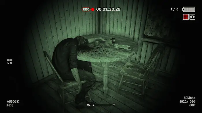Uno screenshot da Outlast 2. Un corpo giace accasciato su un tavolo.