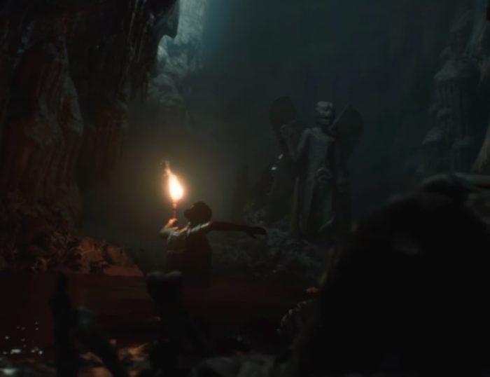 Uno screenshot di un personaggio che vaga attraverso una tomba sotterranea con una torcia da House of Ashes.